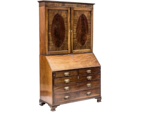 A GEORGE III MAHOGANY BUREAU BOOKCASE, the upper section with a moulded top over a pair of panelled cupboard doors each with 
