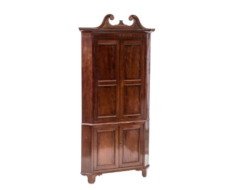 A SUBSTANTIAL GEORGE III MAHOGANY CORNER CUPBOARD ON STAND, the upper section with scroll carved swan neck pediment over a pa