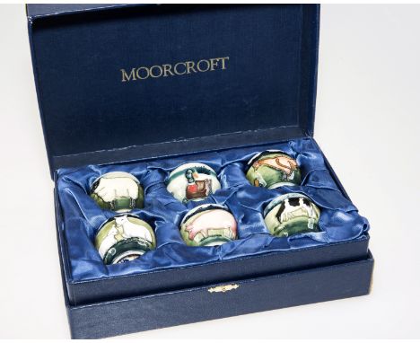 A SET OF SIX MOORCROFT "FARM YARD" POTTERY EGG CUPS, each tubelined and hand painted with farm yard animals, with factory ma