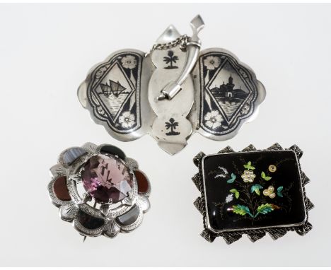 A GROUP OF JEWELLERY COMPRISING: a Scottish silver and hardstone brooch; a late 19th century white metal mounted enamel brooc