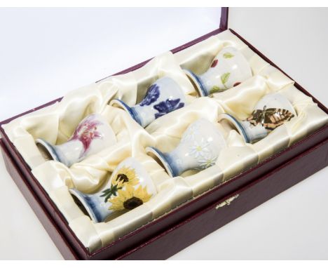 A SET OF SIX COBRIDGE "SPRING TIME" SALT GLAZED EGG CUPS, each hand painted and decorated with flowers and insects, with imp