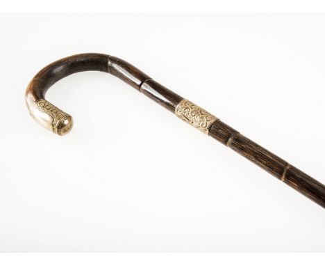 A GOLD-MOUNTED WALKING STICK, c.1900, the gold scroll-decorated mount and collar stamped "18ct", on a bamboo shaft. 87cm 