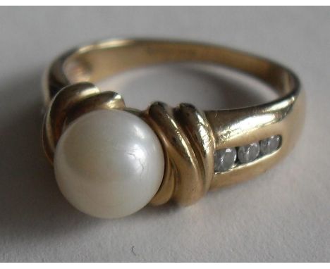 A cultured pearl and diamond dress ring centrally set with a cultured pearl bead, measuring approx 6.86mm diameter, each shou