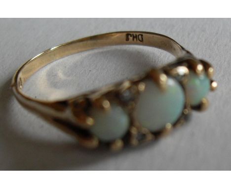 An opal and diamond set ring comprising three circular cabochon-cut white opals (5.5mm, 4.2mm, 4.2mm diam) interspersed with 