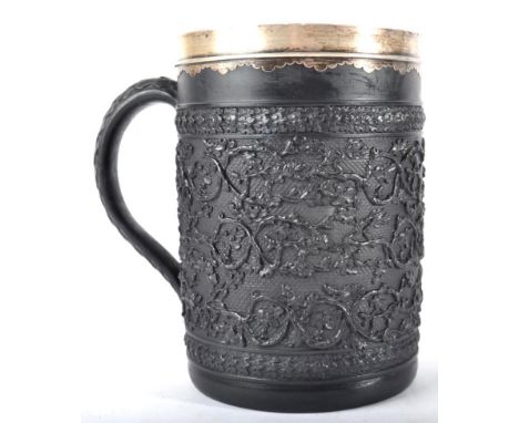 A White Metal Mounted Wedgwood Black Basalt Large Mug, circa 1800, decorated in relief with scrolling foliage on an engine tu