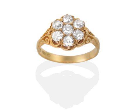 An 18 Carat Gold Old Cut Diamond Cluster Ring, in a carved setting, total estimated diamond weight 1.60 carat approximately, 