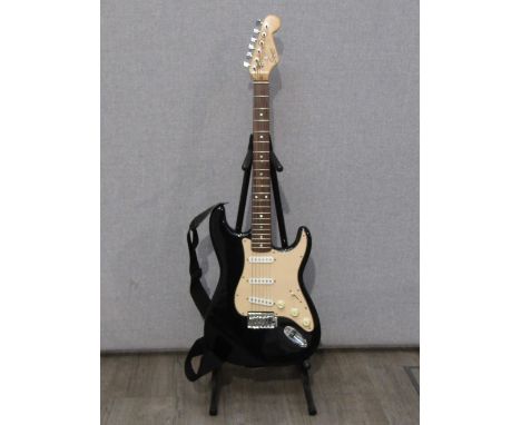 A Fender Squier stratocaster style electric guitar with black body, soft case and a Marshall MG10CD amplifier 