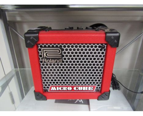 A Roland Micro Cube travel amplifier in red
