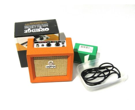 An Orange Micro Crush miniature guitar amplifier, boxed with accessories