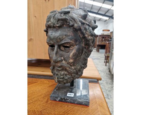 A full-scale classical-style bronze bust of a bearded man, possibly Hercules.