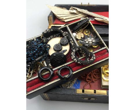 An antique jewellery case and contents including a collection of carved black brooches, earrings, beaded necklets etc, vintag