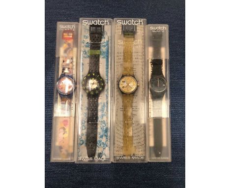 Four Swatch watches in cases including karma sutra, music notes, Scuba, and one other.  