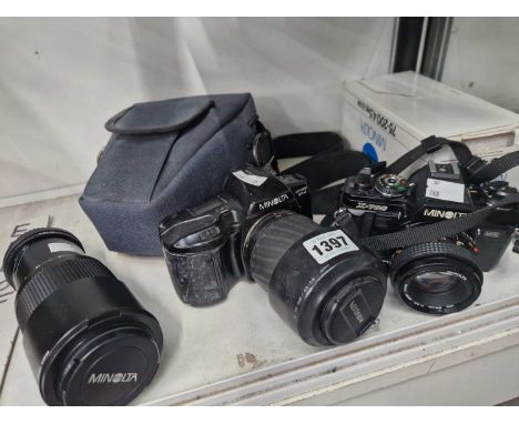 Two Minolta cameras together with cases and a spare lens