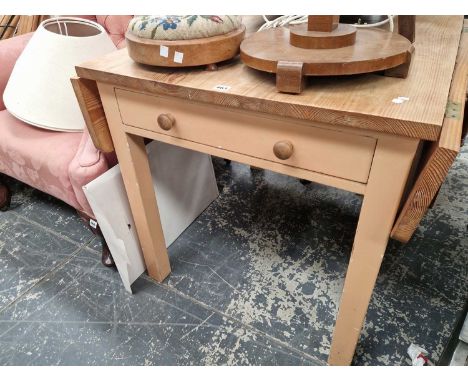 A vintage pine drop-leaf kitchen table.