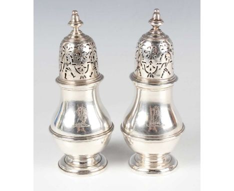 A rare pair of George I silver casters, each domed cover pierced with four harlequins and foliate scrolls beneath a turned kn