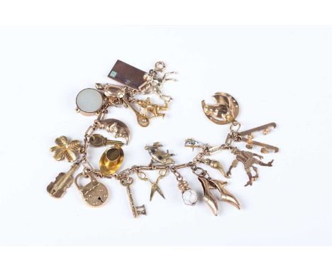 A gold barlink bracelet, fitted with a variety of mostly 9ct gold charms, including an enamelled postcard, a pair of lady's s