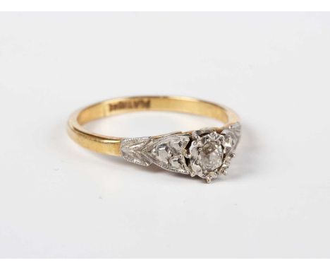 A gold and platinum diamond single stone ring, mounted with a cushion shaped diamond between decorated shoulders, detailed ‘P