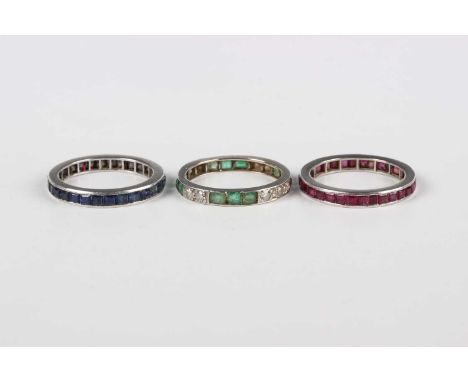 Three gemstone set eternity rings, comprising a ruby eternity ring, mounted with square cut rubies, ring size P1/2, a sapphir