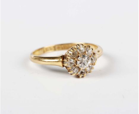 An 18ct gold and diamond cluster ring, claw set with the principal old cut cushion shaped diamond within a surround of eight 