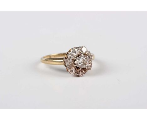 A gold, platinum and diamond eight stone cluster ring, claw set with the principal cushion shaped diamond within a surround o