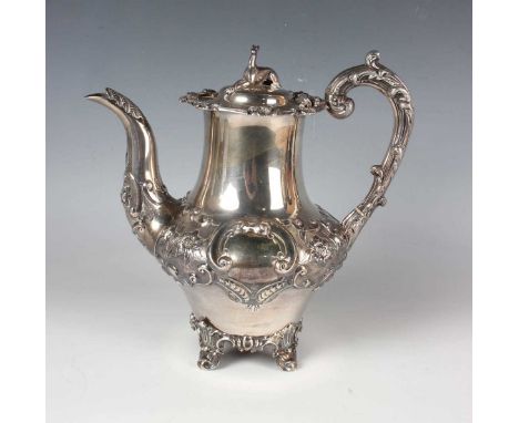 An early Victorian silver baluster hot water pot, the hinged lid with recumbent greyhound finial, the body chased with flower