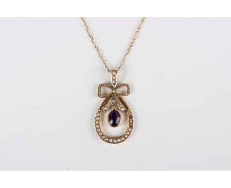 A 9ct gold, amethyst and seed pearl pendant of drop shaped form with a tied bow surmount, collet set with the oval cut amethy
