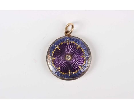 A gold, silver, diamond and enamelled circular pendant locket, glazed with a locket compartment, the interior case back detai