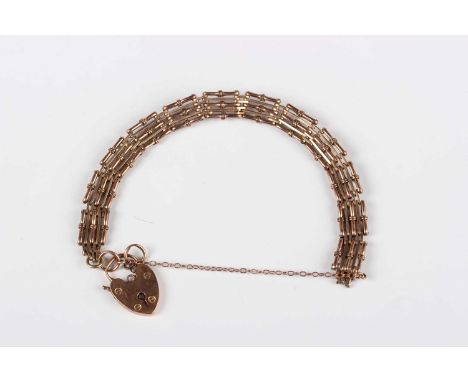 A gold bar and decorated bar link gate bracelet, detailed ‘9c’, on a gold heart shaped padlock clasp, detailed ‘9ct’, weight 