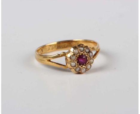 A Victorian 22ct gold, ruby and seed pearl cluster ring, mounted with a cushion shaped ruby within a surround of ten seed pea
