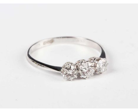 An 18ct white gold and diamond three stone ring, claw set with cushion shaped diamonds, detailed '18ct', weight 2g, ring size