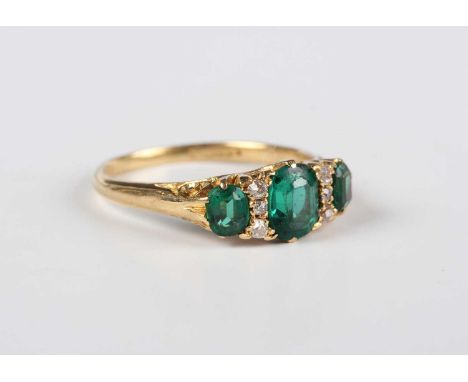 An 18ct gold, green stone topped doublet and diamond ring, mounted with three green gems alternating with two rows of three c