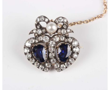 A late Victorian gold backed and silver set, sapphire and diamond brooch, designed as twin hearts with a tied ribbon bow surm
