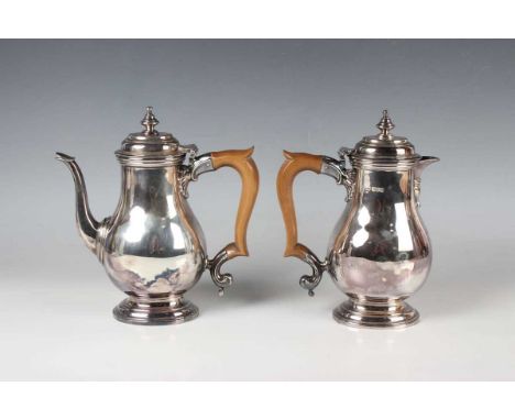 A pair of Edward VIII silver café-au-lait pots, each of oval baluster form with hinged lid and knop finial, on an oval steppe