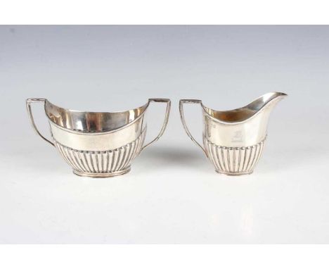 An Edwardian silver two-handled oval half-reeded sugar bowl and matching cream jug, London 1908 by Goldsmiths &amp; Silversmi