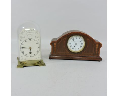 An Edwardian mahogany and inlaid mantel clock, together with a brass anniversary clock, under a glass dome, 21cm tall