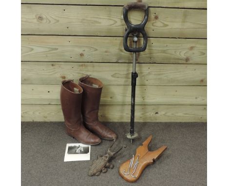 A pair of brown leather riding boots, together with a photograph of the owner, a folding boot pull, a cast iron boot pull and