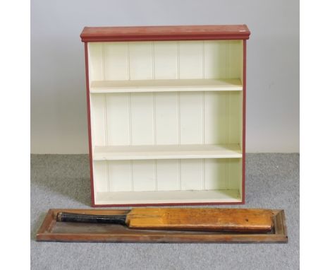 A red painted wall shelf, 66cm, together with a mounted cricket bat 