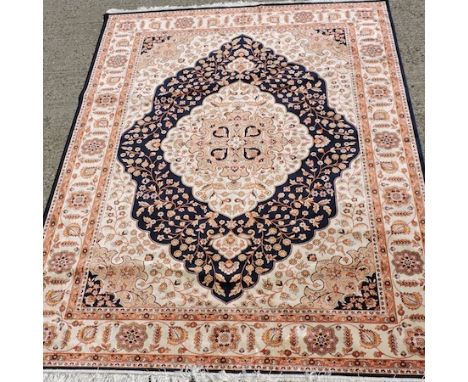 A Kum carpet, with a central medallion and floral designs, on a blue ground, 280 x 200cm