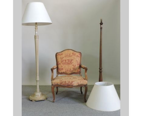 A 20th century upholstered open armchair, together with a cream painted standard lamp and another