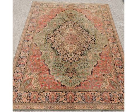 A Persian style carpet, with a central medallion and floral designs, on a green ground, 417x 315cm
