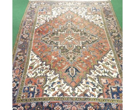 A Persian Heriz carpet, with floral designs on a red ground, 293 x 204cm