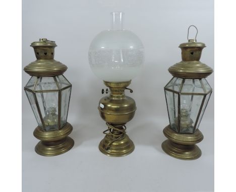 A pair of brass and glass hanging lanterns, 45cm tall, together with a brass oil lamp