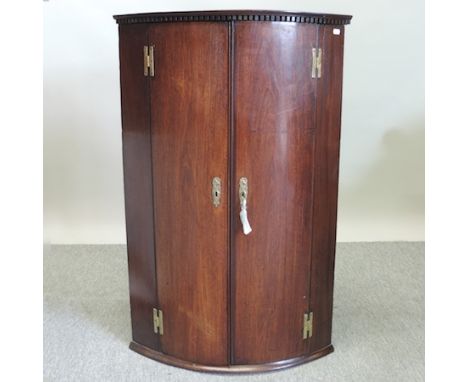 A George III mahogany bow front hanging corner cabinet, 62cm