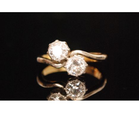An 18ct diamond two stone cross over ring, two brilliant cut claw set stones each approximately .40ct, ring size K. 
