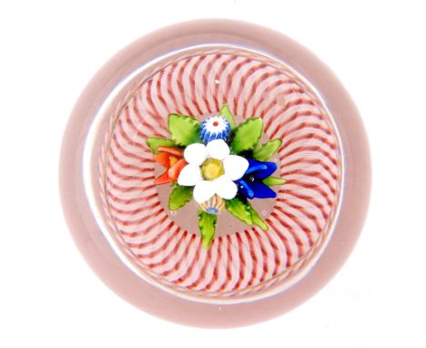 A 19th Century French paperweight by St Louis decorated with an upright bouquet having three lamp worked flowers with two can