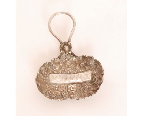 A George III hallmarked silver caddy spoon, the bowl profusely chased and embossed with leaves, berries, scrollwork and a lio