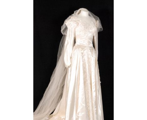 A 1950s vintage duchess satin wedding dress, the boat neck bodice decorated with ivy leaves and lustre sequins with full leng