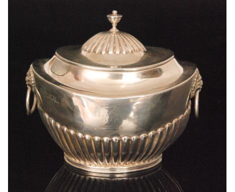 A Victorian hallmarked silver half fluted tea caddy of oval outline with hinged lid and two lion mask capped ring handles, we