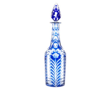A 19th Century bottle form decanter with spire form stopper, cased in blue over clear crystal and flash cut with a stylised f