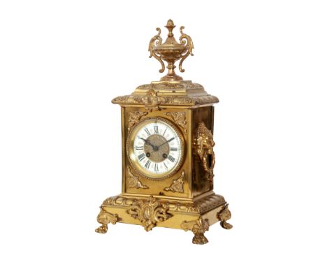 A late 19th Century French gilt mantle clock with eight day movement striking on a bell, the case surmounted with a twin hand